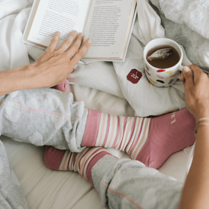 woman wearing pink merino wool socks in bed nz
