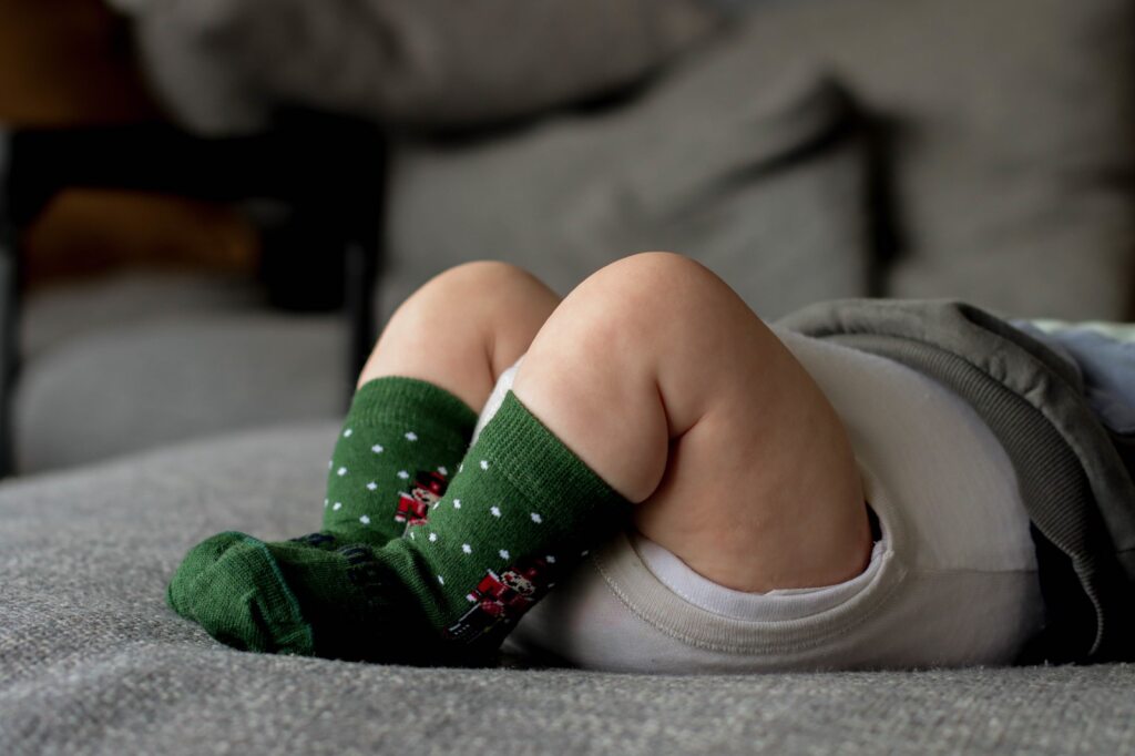 Newborn celebrating first Christmas in Lamington green Nutcracker socks